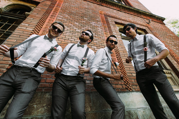 Stylish groomsmen in the suspenders and bow-ties - Foto, imagen