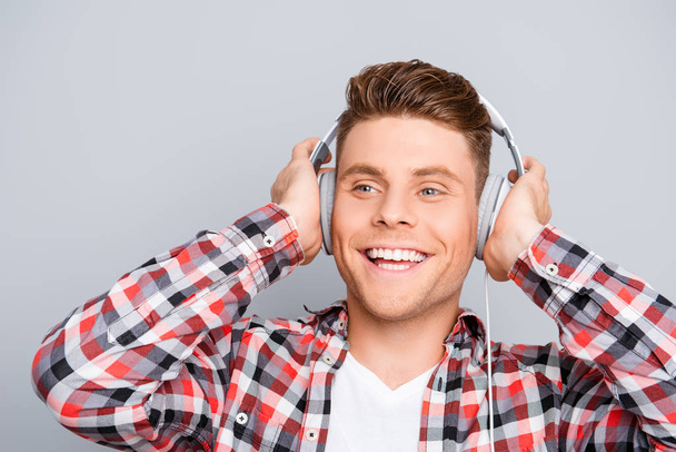 Portrait of happy young man  listening music in headphones - Photo, Image