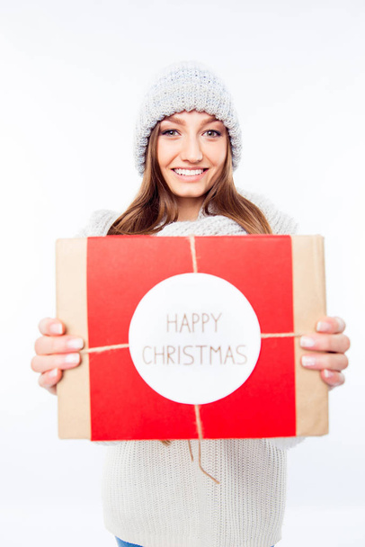 Cheerful woman  in warm hat and scarf holding package and congra - Zdjęcie, obraz