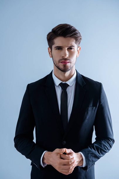 Portrait of serious young  successful businessman with clasped h - Foto, Imagem