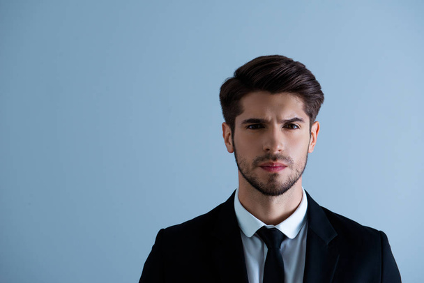 Portrait of serious brutal young man in black suit - Foto, immagini
