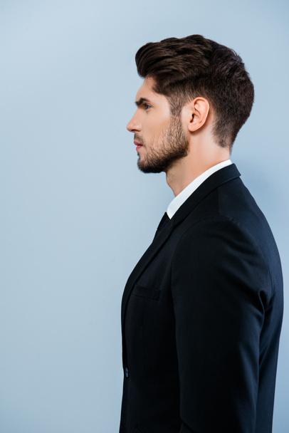Vista lateral de homem sério confiante em terno preto
 - Foto, Imagem