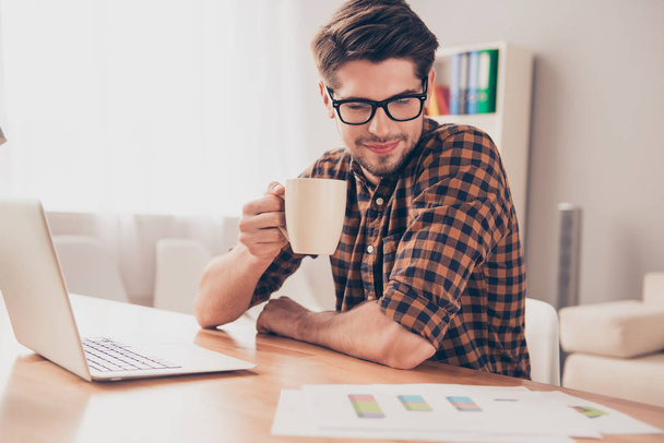 Smart young businessman drinking coffee and reading diagrama - Foto, afbeelding