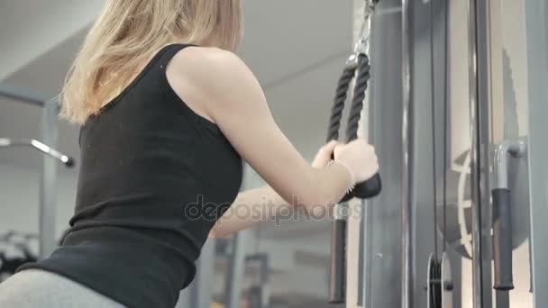 Ejercicio de chica fuerte con simulador de gimnasio para músculos en 4K
 - Imágenes, Vídeo