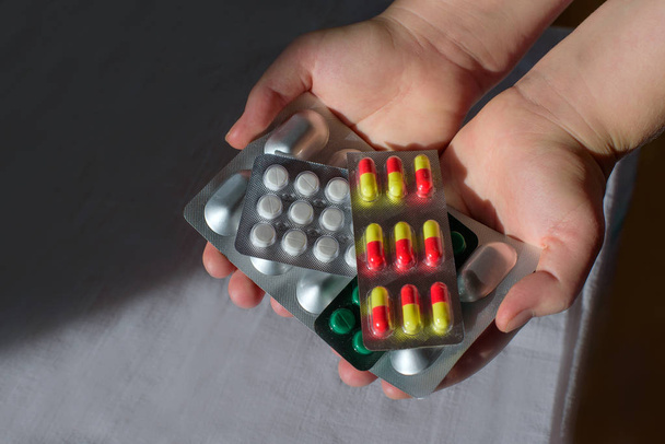 naisen kädet pitämällä kourallinen pillereitä lääkettä
 - Valokuva, kuva