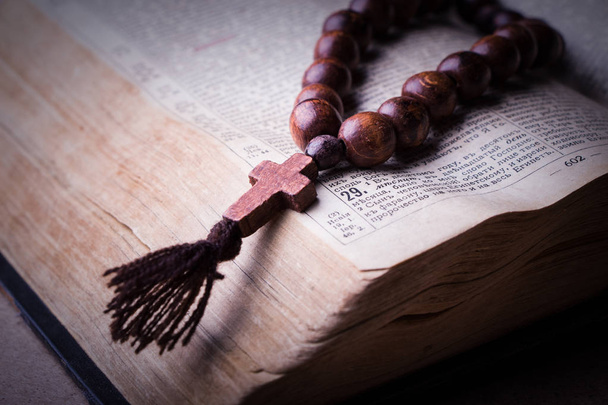 Rosario en la Biblia sobre un fondo de madera. Libro sagrado
. - Foto, imagen