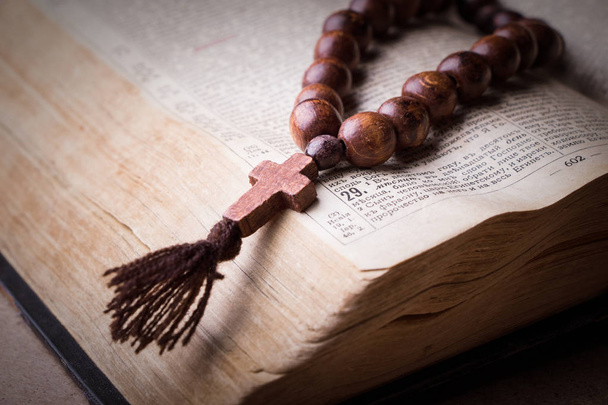 Rozenkrans op de Bijbel op een houten achtergrond. Heilig boek. - Foto, afbeelding
