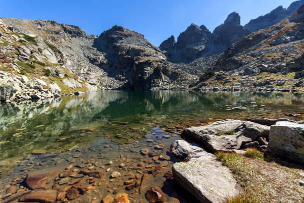 Niesamowity widok straszny jeziora i szczytami Kupens, góry Riła - Zdjęcie, obraz
