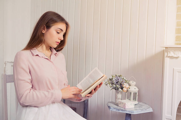 Tyttö lukee kirjaa. Kaunis nuori tyttö pusero ja hame
 - Valokuva, kuva