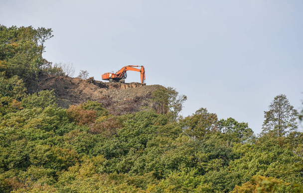 Excavadora de pie en la cima de la colina de grava
 - Foto, Imagen