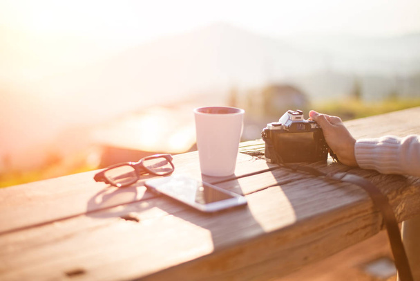 Mulher bebendo café e tirar uma foto ao sol sentado ao ar livre em luz do sol
 - Foto, Imagem