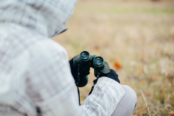 Young woman looking through binoculars on a autumn nature. Binoc - Foto, immagini
