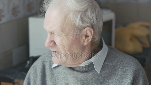 Old sad grandfather looking at the window and camera 4K - Footage, Video
