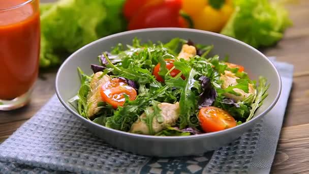 Salada fresca com frango, tomate, arugula, mesclun, manjericão e suco de tomate em um guardanapo de pano, na mesa de madeira
 - Filmagem, Vídeo