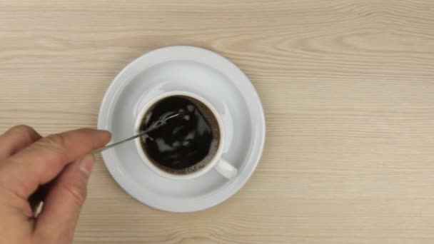 Mão colocando açúcar colher em uma xícara de café e mexendo-o para colocar a colher no pires
 - Filmagem, Vídeo