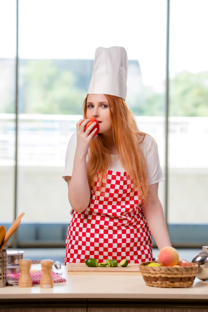 Punapää kokki työskentelee keittiössä
 - Valokuva, kuva