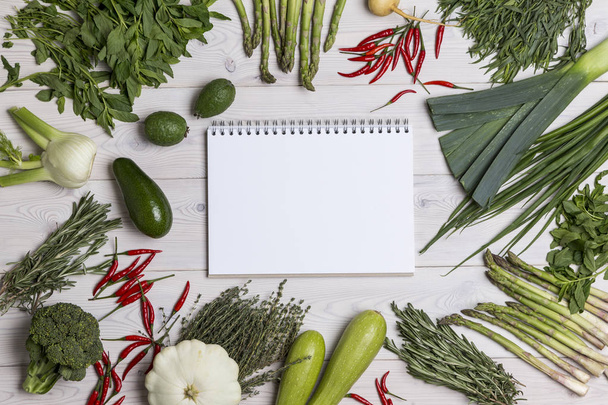 Σημειωματάριο με ένα ελατήριο στο τραπέζι με λαχανικά - Φωτογραφία, εικόνα