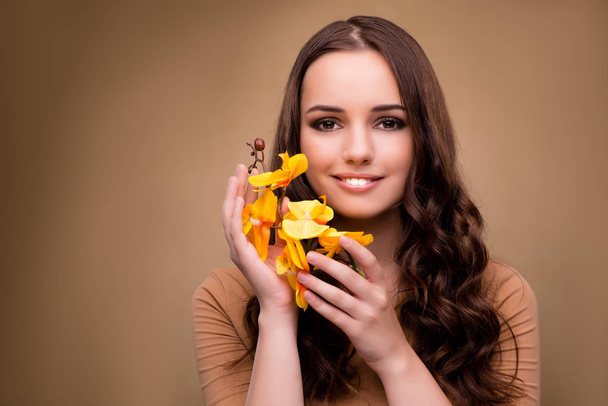 Beautiful woman with yellow orchid flower - Photo, Image