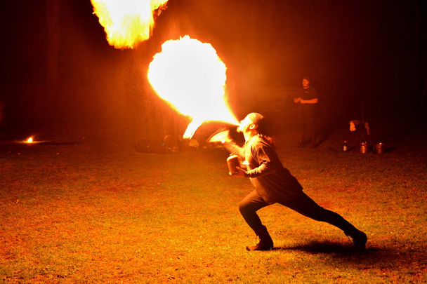 Fire show - artist spitting out fire in the dark - Foto, immagini
