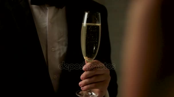 Close up of young man wearing classical suit with a glass of champagne on his hands. - Πλάνα, βίντεο