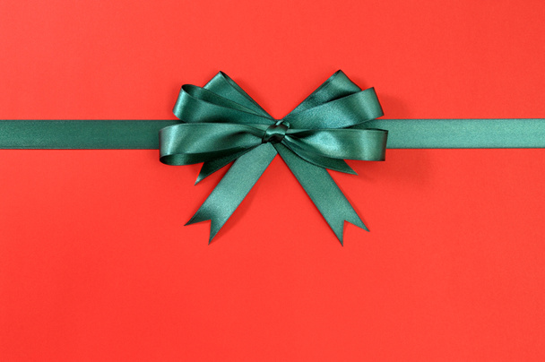 Nastro regalo verde fiocco dritto orizzontale su carta rossa backgroun
 - Foto, immagini