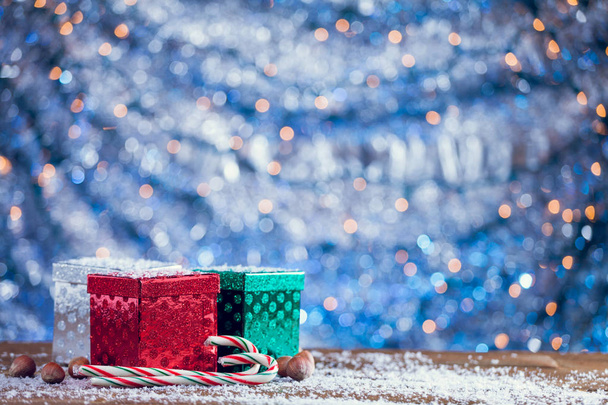 Small Colorful Christmas Gift Boxes On Snowy Wood Background - Foto, immagini