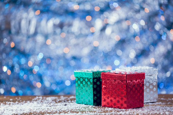 Small Colorful Christmas Gift Boxes On Snowy Wood Background. - Foto, Imagem