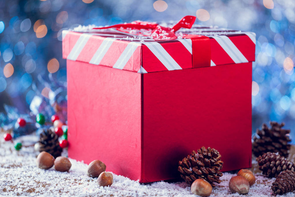 Red Striped Christmas Gift Box With Decoration On Snowy Wood - Фото, зображення