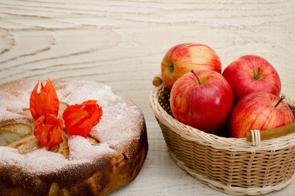 Яблочный пирог, Физические цветы и спелые яблоки на светлом деревянном столе, крупным планом
 - Фото, изображение