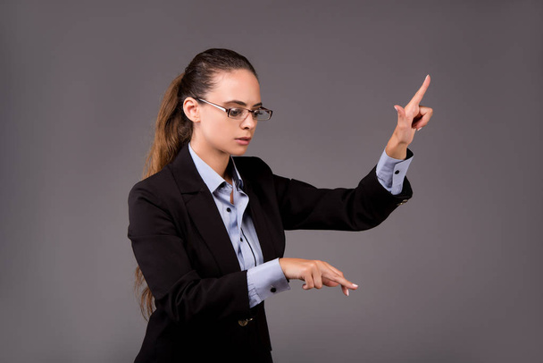 Молодая женщина-бизнесмен нажимает виртуальные кнопки
 - Фото, изображение