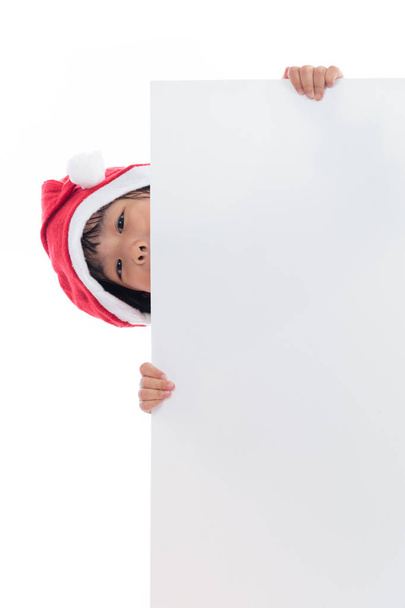Happy Asian Chinese little santa girl peeking behind blank board - Fotoğraf, Görsel