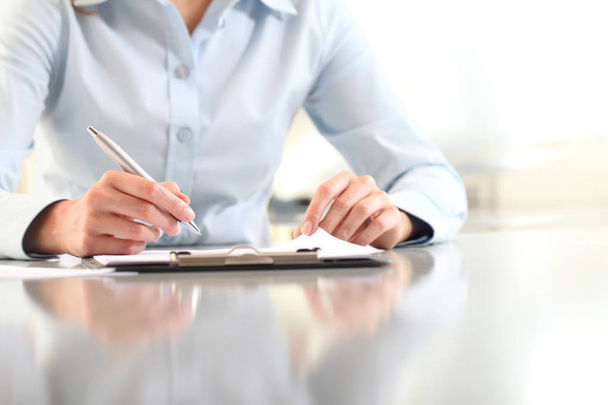 femme mains écriture sur presse-papiers avec un stylo, isolé sur le bureau
 - Photo, image