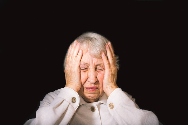 Femme âgée avec tête dans les mains à la recherche lasse
 - Photo, image