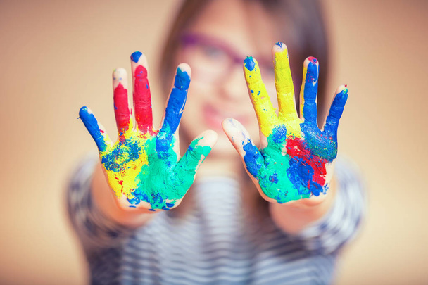 Retrato de una niña preadolescente mostrando las manos pintadas. Foto tonificada
 - Foto, imagen