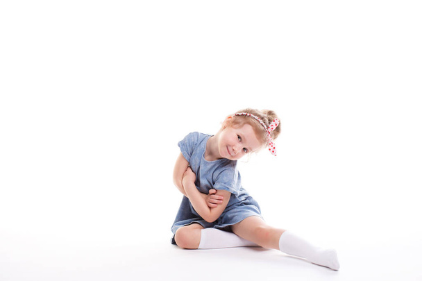 Closeup image of a pretty little girl sitting on the floor. - Фото, зображення