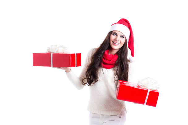Beautiful woman in santa hat holding two gifts. Concept of the New Year sales. New Year bonus. - Foto, afbeelding