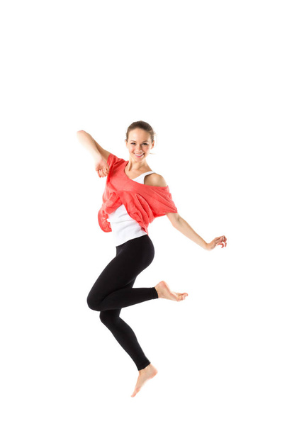 Cheerful, athletic girl jumping and looking into the camera. Isolated. - Foto, imagen