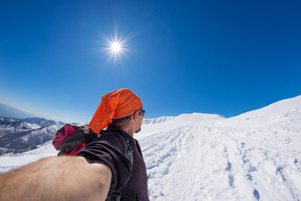 Adult alpin skier with beard, sunglasses and hat, taking selfie on snowy slope in the beautiful italian Alps with clear blue sky. Concept of wanderlust and adventures on the mountain. Wide angle fishe - Photo, Image