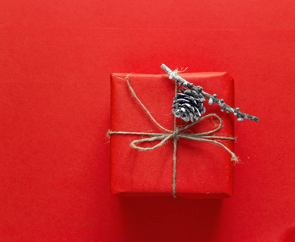 Red gift box with a bump on a red background. Christmas backgrou - Φωτογραφία, εικόνα
