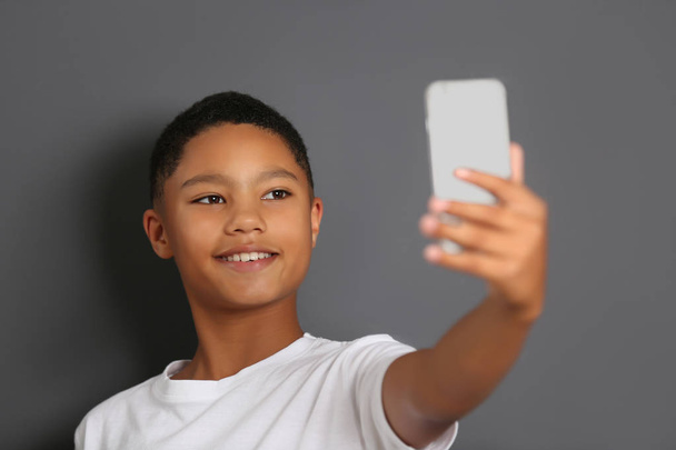 携帯電話を持つアフリカ系アメリカ人の少年   - 写真・画像