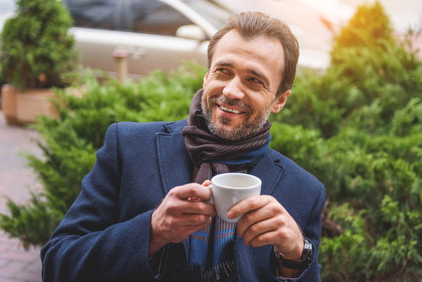 Joyful businessman enjoying hot beverage - Фото, изображение