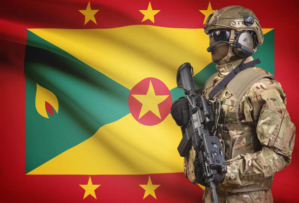 Солдат в шлеме, держа пистолет с флагом на фоне серии - Гренада - Фото, изображение