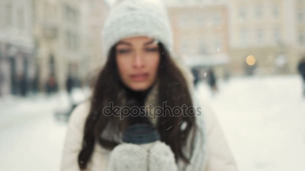幸福、冬休み、クリスマス、飲料、人々 の概念 - 白暖かい服の若い女性の笑顔と奪う雪都市の背景の上にコーヒーを飲む - 映像、動画