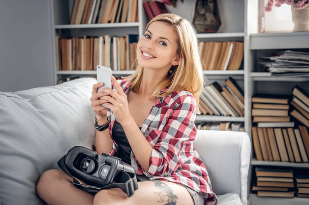 Tyttö käyttää älypuhelinta ja virtuaalilaseja
 - Valokuva, kuva