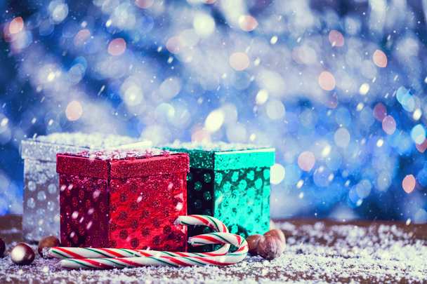 Snow Falling On Small Colorful Christmas Gift Boxes. Vintage Filter Applied. - Foto, afbeelding