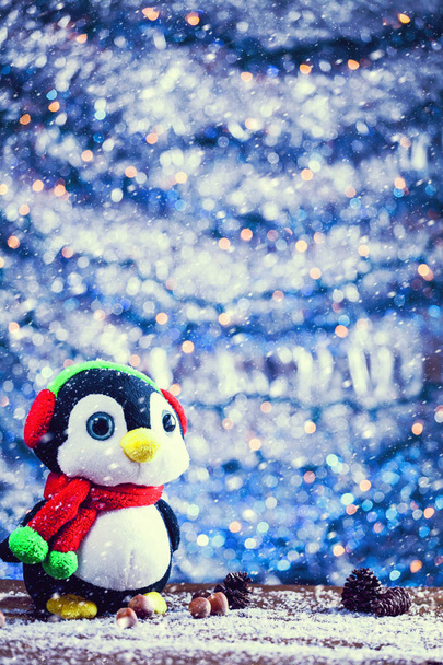 Сніг падає на милий щасливий пінгвін Різдвяна іграшка посміхається. Урожайний фільтр Застосовано
. - Фото, зображення