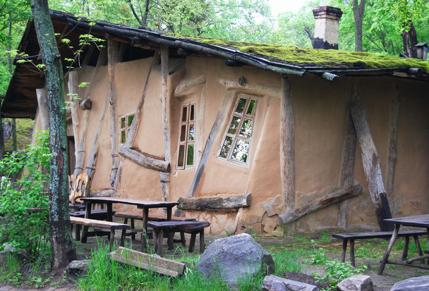 ongebruikelijke kromme oude hut in donker hout - Foto, afbeelding