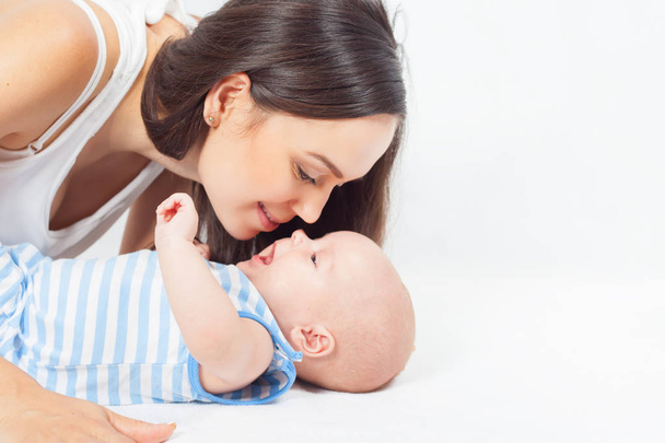 Happy mother holding a baby boy at white background - Photo, Image