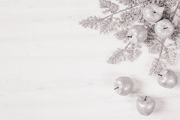 Christmas silver sprigs and apples decoration  on wooden white  background. - Фото, изображение