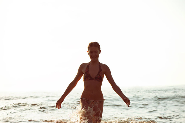 Силуэт девушки, развлекающейся в Балтийском море плескающейся волной
 - Фото, изображение